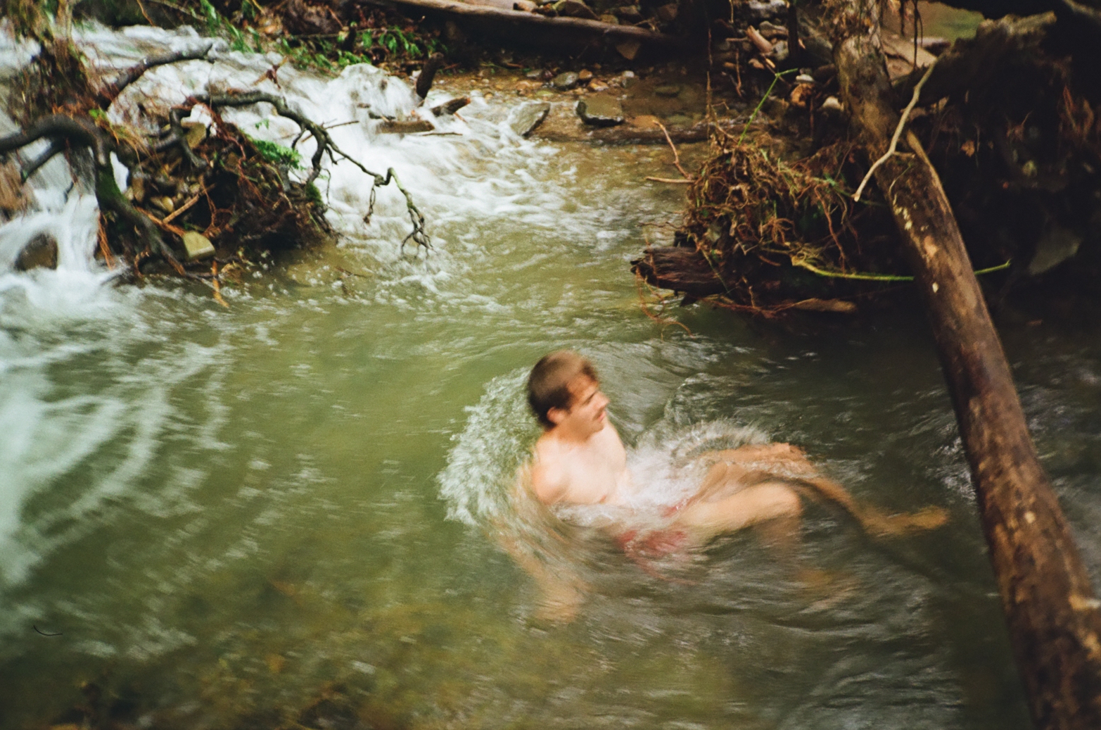 Person swimming in natural creek