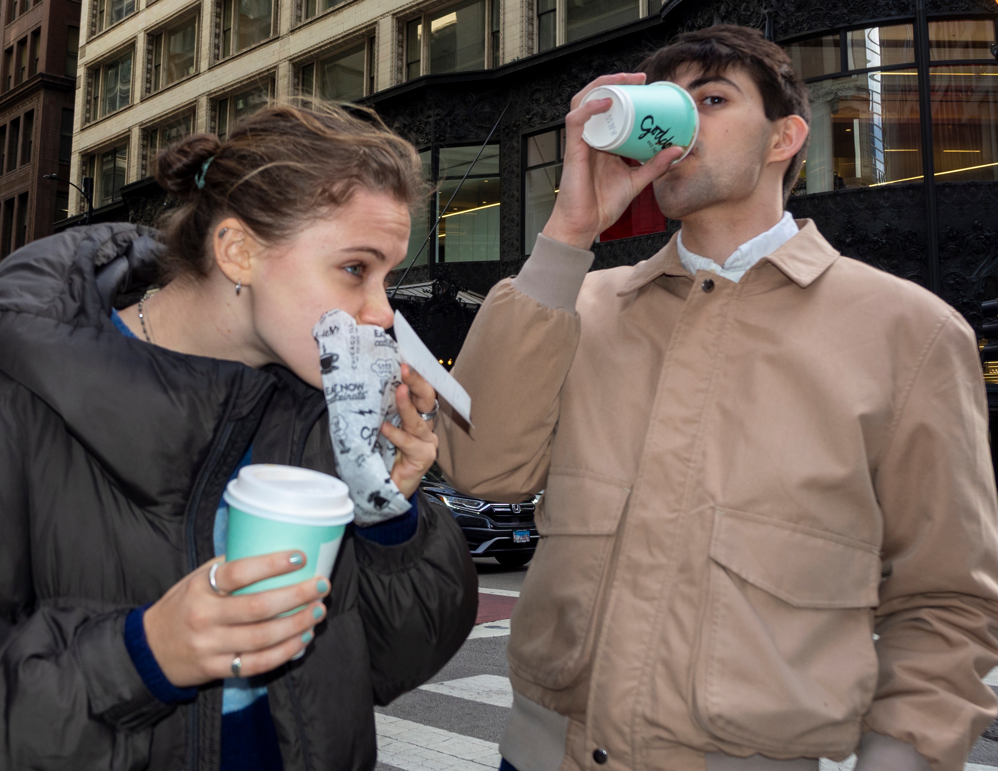 Young couple with coffee cups on busy Chicago street