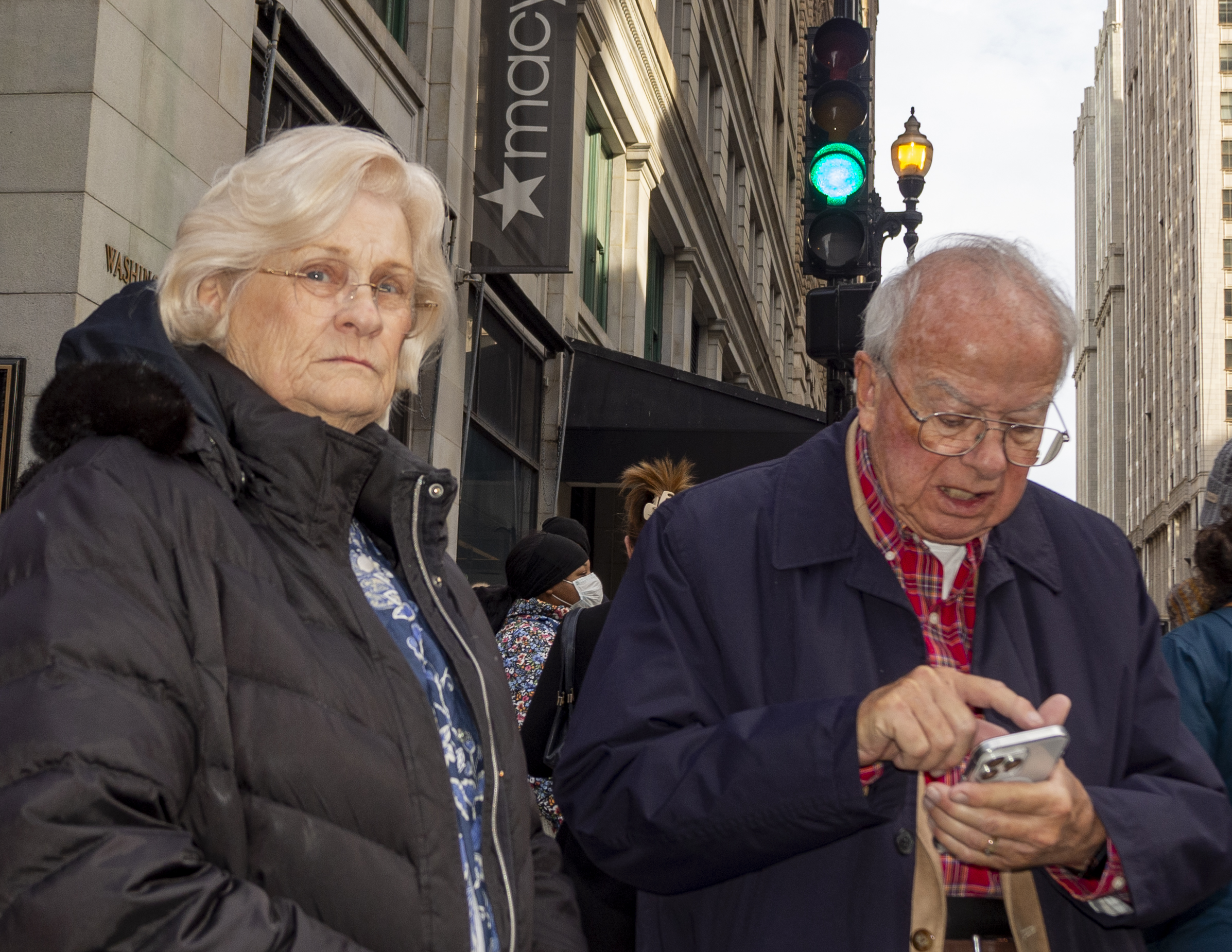 Elderly couple on Chicago street, man checking phone