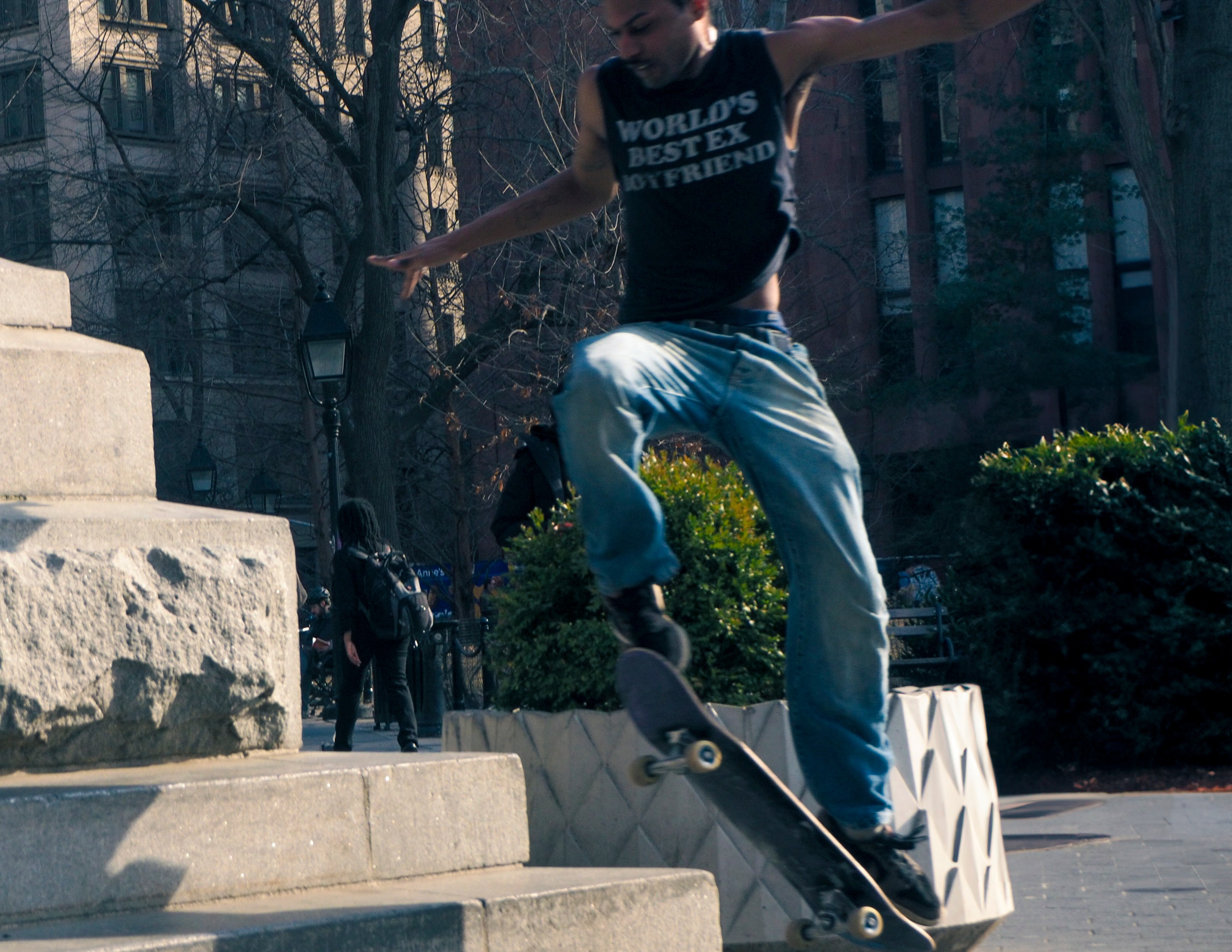 Skateboarder performing trick in Washington Square Park area